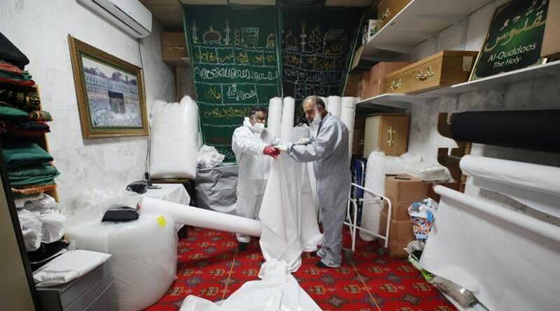 Workers prepare shrouds to wrap bodies in the Central Jamia Mosque Ghamkol Sharif, which is currently being used as a temporary morgue in Birmingham, UK, April 21, 2020 [Carl Recine/Reuters]