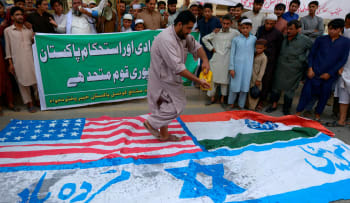 A Sunni Muslim prepares to torch flags of US, India and Israel during a rally against Israel and United States to mark the Al-Quds (Jerusalem) Day in Ramadan. Peshawar, May 22, 2020

