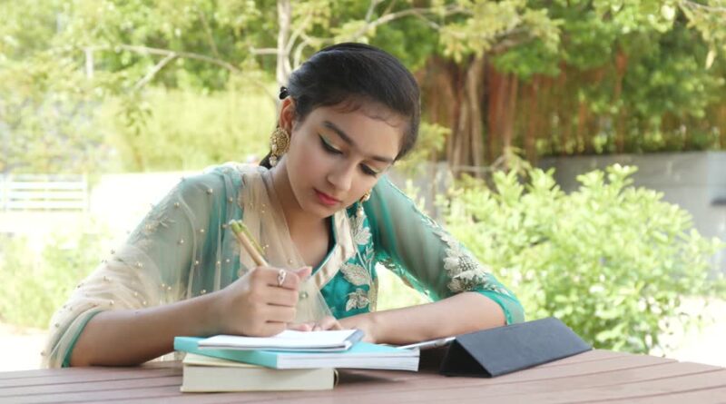 Young Pakistani girl study on tablet and book